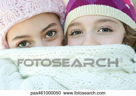 Two young friends covering mouths with scarf, looking at camera, portrait View Large Photo Image Stock Image - Two young friends covering mouths with scarf, looking at camera, portrait. Fotosearch