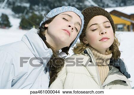 Two young friends in winter clothes, side by side, eyes closed, portrait View Large Photo Image Picture - Two young friends in winter clothes, side by side, eyes closed, portrait. Fotosearch