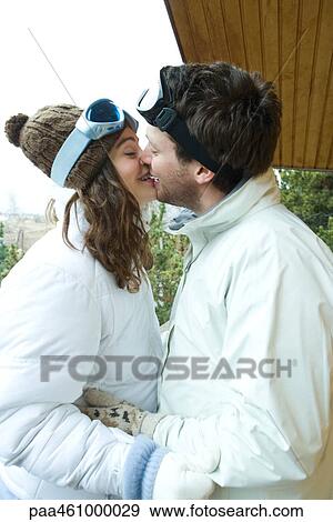 Young couple kissing, face to face, dressed in winter clothing, side view View Large Photo Image Stock Photo - Young couple kissing, face to face, dressed in winter clothing, side view. Fotosearch