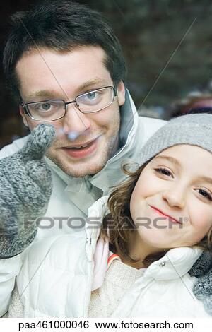 Young man looking over little sister's shoulder and pointing, both smiling at camera, portrait View Large Photo Image Stock Photograph - Young man looking over little sister's shoulder and pointing, both smiling at camera, portrait. Fotosearch