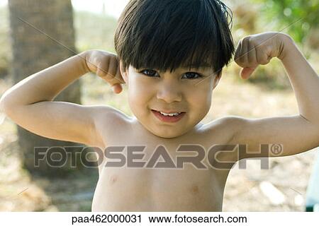 Boy with arms raised, flexing muscles, smiling at camera, portrait View Large Photo Image Stock Image - Boy with arms raised, flexing muscles, smiling at camera, portrait. Fotosearch
