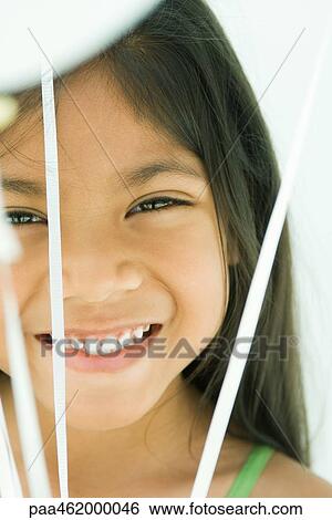 Girl grinning at camera from behind bunch of balloon strings, portrait View Large Photo Image Stock Photograph - Girl grinning at camera from behind bunch of balloon strings, portrait. Fotosearch