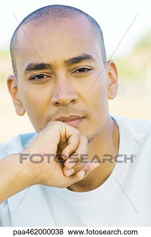 Man with shaved head looking at camera, hand under chin, portrait View Large Photo Image Stock Photo - Man with shaved head looking at camera, hand under chin, portrait. Fotosearch
