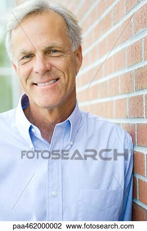 Stock Image - Mature man smiling at camera, portrait. Fotosearch