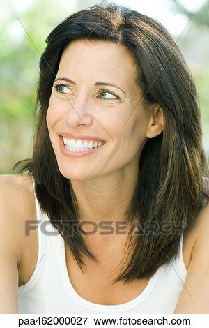 Stock Photo - Woman smiling, looking away, portrait. Fotosearch