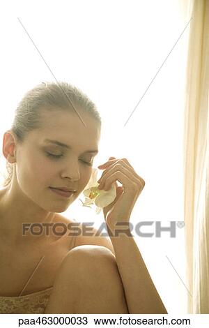 Teen girl holding orchid flower to face View Large Photo Image Stock Image - Teen girl holding orchid flower to face. Fotosearch