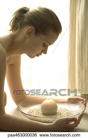 Stock Photograph - Teen girl leaning over candle. Fotosearch