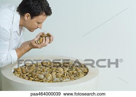 Man holding hands full of pebbles, leaning forward, side view View Large Photo Image Stock Photo - Man holding hands full of pebbles, leaning forward, side view. Fotosearch