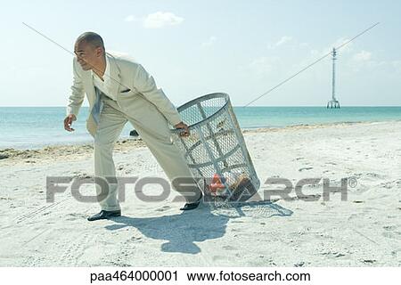 Man in suit pulling garbage can across sunny beach, full length View Large Photo Image Stock Image - Man in suit pulling garbage can across sunny beach, full length. Fotosearch