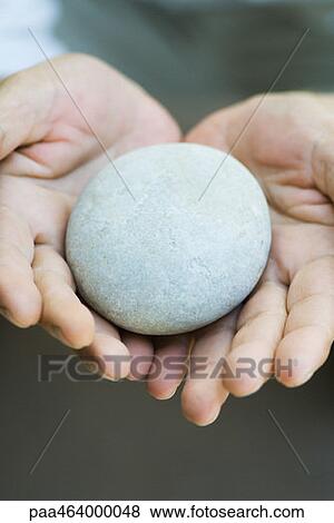 Pebble in cupped hands, close-up View Large Photo Image Stock Photo - Pebble in cupped hands, close-up. Fotosearch