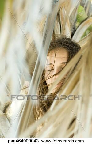 Woman closing eyes, hair blowing in wind, surrounded by dry foliage, selective focus View Large Photo Image Stock Image - Woman closing eyes, hair blowing in wind, surrounded by dry foliage, selective focus. Fotosearch