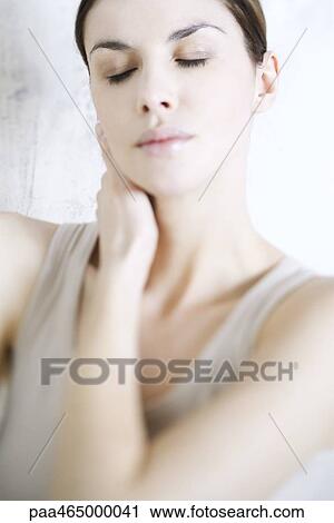 Woman holding neck, eyes closed View Large Photo Image Stock Image - Woman holding neck, eyes closed. Fotosearch