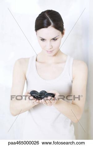 Woman holding pebbles, looking down, waist up View Large Photo Image Stock Photograph - Woman holding pebbles, looking down, waist up. Fotosearch