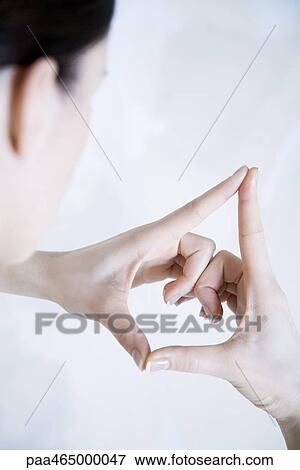Stock Photo - Woman making gesture with hands, over the shoulder view. Fotosearch