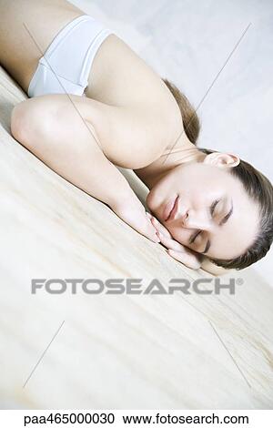 Woman reclining in floor, head resting on arms, eyes closed View Large Photo Image Stock Image - Woman reclining in floor, head resting on arms, eyes closed. Fotosearch
