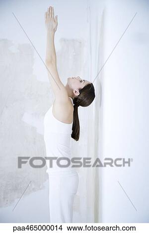Woman standing, stretching, arms raised, head back View Large Photo Image Picture - Woman standing, stretching, arms raised, head back. Fotosearch