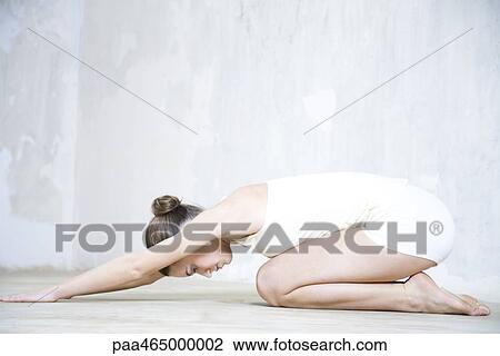 Young woman doing yoga pose, side view, full length View Large Photo Image Stock Image - Young woman doing yoga pose, side view, full length. Fotosearch