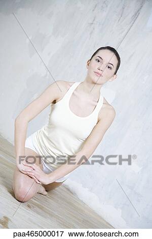 Young woman stretching, smiling at camera, tilted view View Large Photo Image Stock Photo - Young woman stretching, smiling at camera, tilted view. Fotosearch