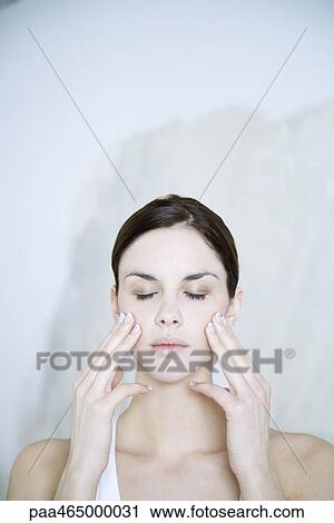 Young woman touching cheeks, eyes closed, portrait View Large Photo Image Stock Image - Young woman touching cheeks, eyes closed, portrait. Fotosearch