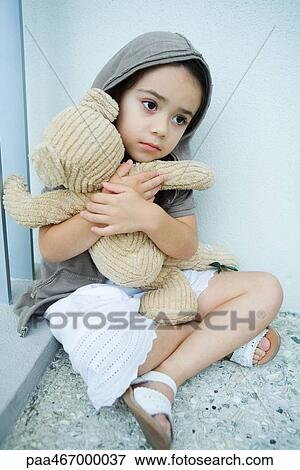 Little girl sitting on floor, clutching teddy bear View Large Photo Image Stock Photo - Little girl sitting on floor, clutching teddy bear. Fotosearch