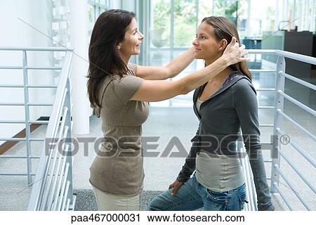 Mother and teenage girl together, woman pushing daughter's hair back, side view View Large Photo Image Stock Image - Mother and teenage girl together, woman pushing daughter's hair back, side view. Fotosearch