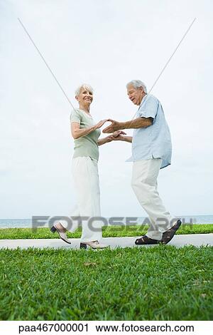 Senior couple dancing on sidewalk overlooking ocean, full length View Large Photo Image Stock Image - Senior couple dancing on sidewalk overlooking ocean, full length. Fotosearch