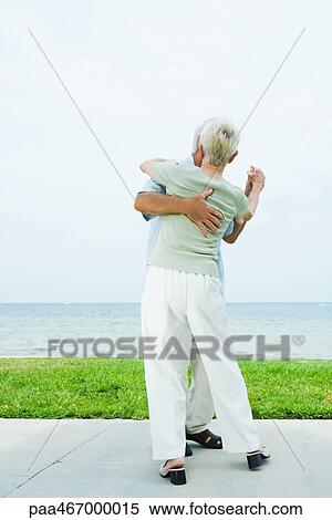 Senior couple dancing on sidewalk overlooking ocean, full length View Large Photo Image Stock Photography - Senior couple dancing on sidewalk overlooking ocean, full length. Fotosearch