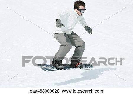 Stock Photo - Snowboarder doing trick, full length. Fotosearch