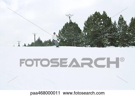 Stock Image - Snowboarder in mid distance, full length. Fotosearch