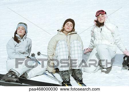 Three teen girl skiers sitting in snow, eyes closed, heads back View Large Photo Image Stock Image - Three teen girl skiers sitting in snow, eyes closed, heads back. Fotosearch
