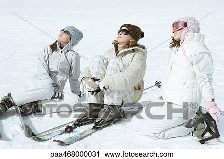 Three teen girl skiers sitting in snow, wearing sunglasses, heads back View Large Photo Image Stock Image - Three teen girl skiers sitting in snow, wearing sunglasses, heads back. Fotosearch
