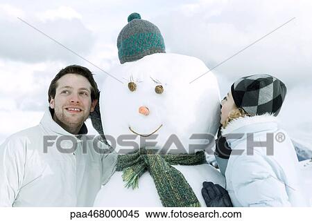 Two young friends on other side of snowman, one whispering, the other listening View Large Photo Image Stock Photography - Two young friends on other side of snowman, one whispering, the other listening. Fotosearch