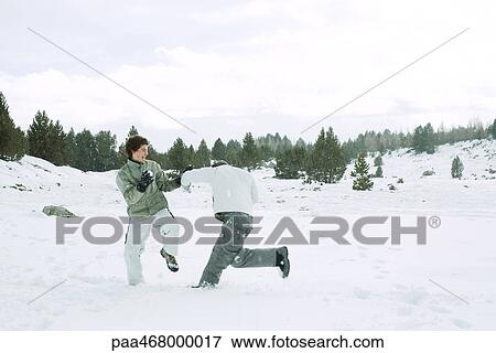 Two young male friends roughhousing in snow, full length View Large Photo Image Stock Photo - Two young male friends roughhousing in snow, full length. Fotosearch