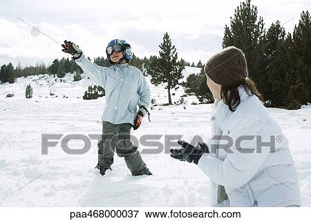 Stock Photo - Young friends having snowball fight, action shot. Fotosearch