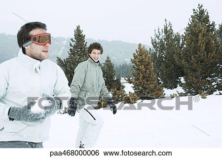 Young male friends in the snow, one holding a snowball View Large Photo Image Stock Photograph - Young male friends in the snow, one holding a snowball. Fotosearch