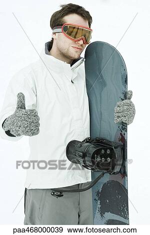 Young male snowboarder, giving thumbs up sign to camera View Large Photo Image Stock Photo - Young male snowboarder, giving thumbs up sign to camera. Fotosearch