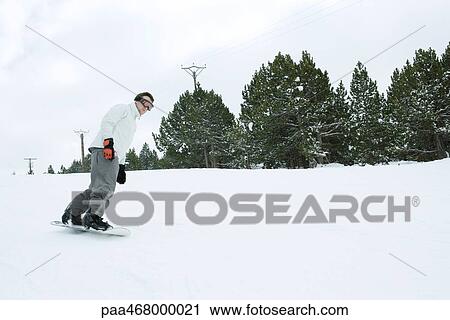 Young man snowboarding, full length View Large Photo Image Stock Image - Young man snowboarding, full length. Fotosearch