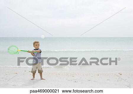 Little boy standing on beach, catching ball with net, full length View Large Photo Image Stock Image - Little boy standing on beach, catching ball with net, full length. Fotosearch