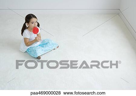 Little girl sitting on floor, licking large lollipop View Large Photo Image Stock Photo - Little girl sitting on floor, licking large lollipop. Fotosearch