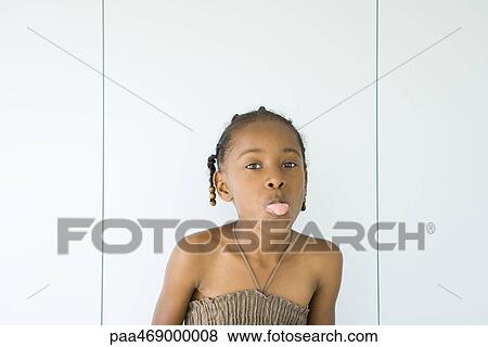 Little girl wearing halter top, sticking out tongue at camera, portrait View Large Photo Image Stock Photo - Little girl wearing halter top, sticking out tongue at camera, portrait. Fotosearch