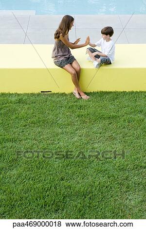 Mother and boy sitting outdoors, playing clapping game, high angle view, full length View Large Photo Image Stock Photo - Mother and boy sitting outdoors, playing clapping game, high angle view, full length. Fotosearch