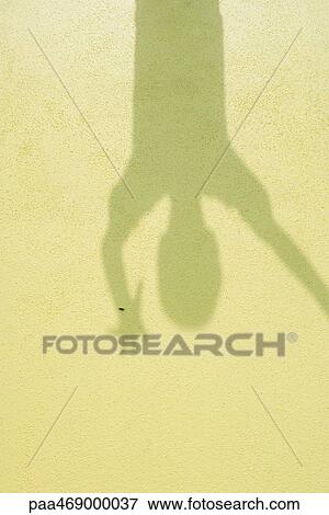 Shadow on yellow surface, arm raised and fingers spread, upside down View Large Photo Image Stock Photo - Shadow on yellow surface, arm raised and fingers spread, upside down. Fotosearch