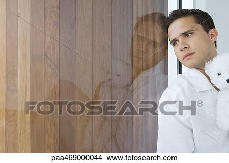 Young man holding teddy bear with image reflected in glass View Large Photo Image Picture - Young man holding teddy bear with image reflected in glass. Fotosearch