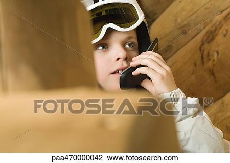 Boy wearing ski goggles, using cell phone, cropped view View Large Photo Image Stock Image - Boy wearing ski goggles, using cell phone, cropped view. Fotosearch