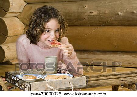 Girl having snack View Large Photo Image Stock Photograph - Girl having snack. Fotosearch