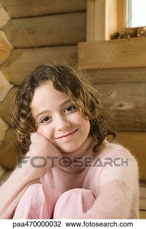 Girl sitting with knees up, smiling at camera View Large Photo Image Stock Image - Girl sitting with knees up, smiling at camera. Fotosearch