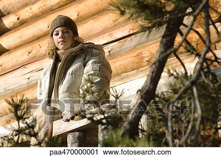 Teen girl standing on deck of log cabin, evergreen in foreground View Large Photo Image Stock Image - Teen girl standing on deck of log cabin, evergreen in foreground. Fotosearch