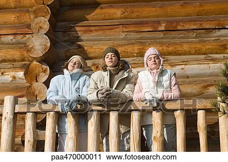 Three preteen or teen girls standing on deck of log cabin, eyes closed, low angle view View Large Photo Image Stock Image - Three preteen or teen girls standing on deck of log cabin, eyes closed, low angle view. Fotosearch