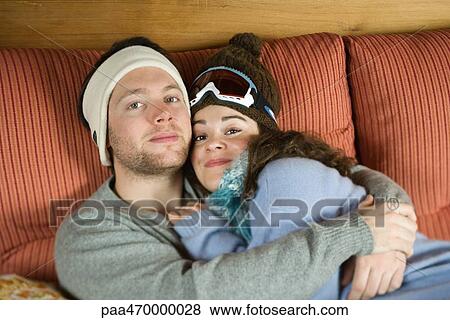 Young couple reclining on sofa together, smiling at camera View Large Photo Image Stock Photo - Young couple reclining on sofa together, smiling at camera. Fotosearch