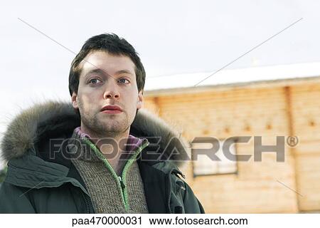 Young man in winter clothing, low angle view View Large Photo Image Stock Image - Young man in winter clothing, low angle view. Fotosearch